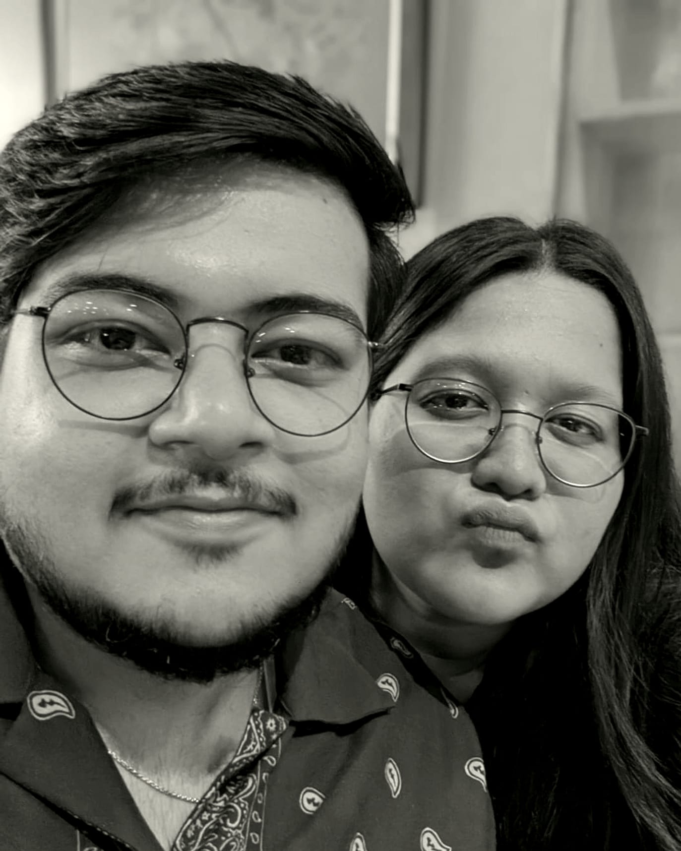 Rachel and Praduan close together, both in round glasses